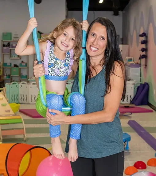 Julie McConn with student on yoga trapeze